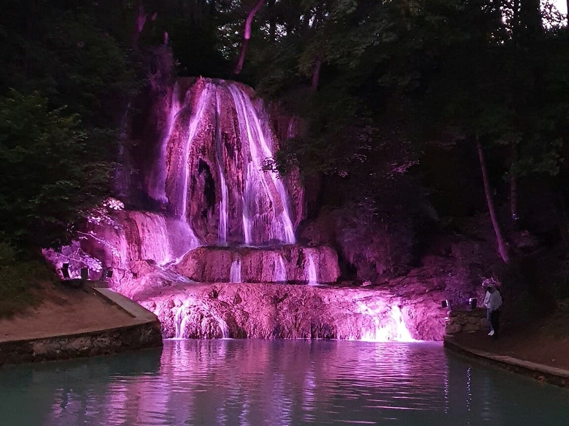 Vodopád Lúčky je osvetlený fialovými svetlami.