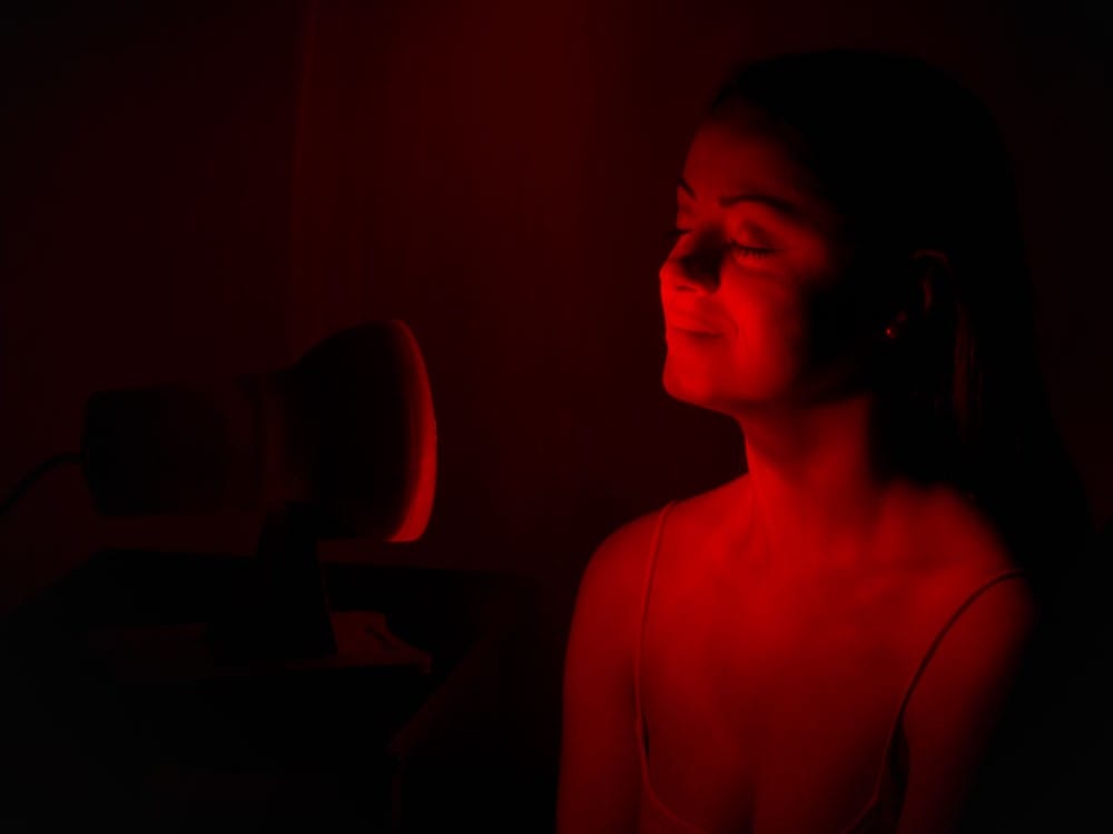 Žena sedí pred červeným svetlom.