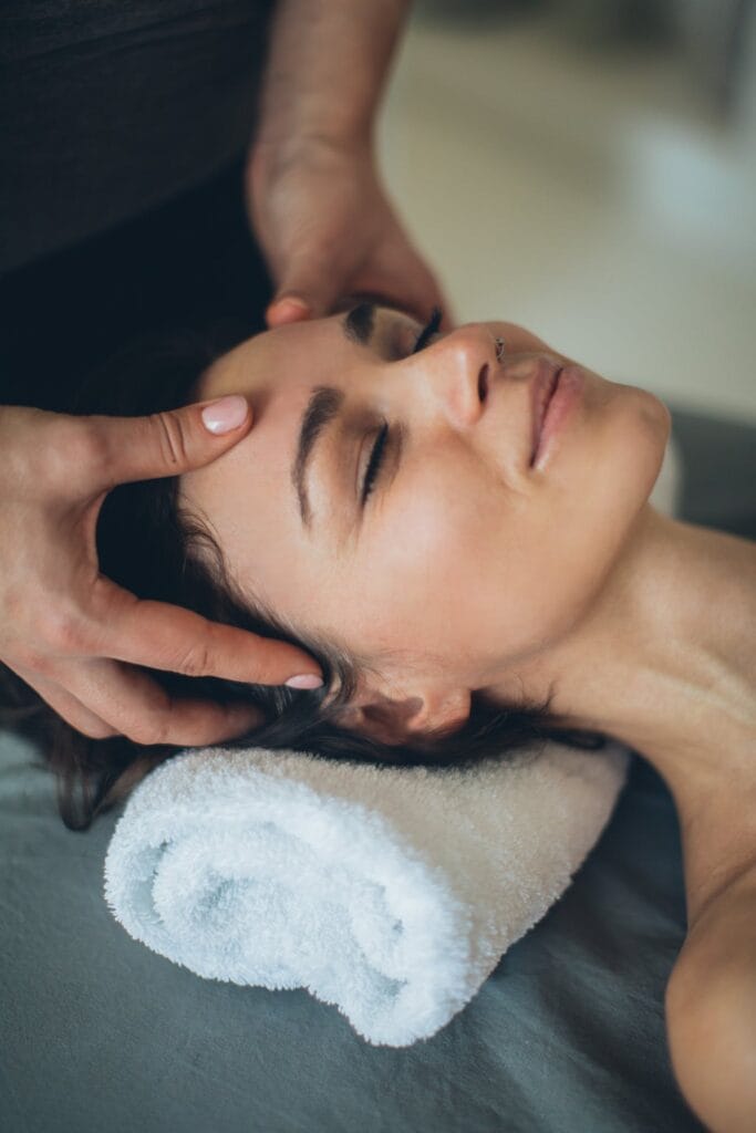 Žena podstupujúca masáž tváre v kúpeľoch na omladenie a osvieženie pleti